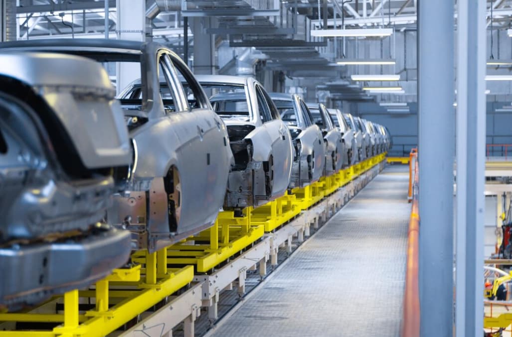 A row of unfinished car bodies on an assembly line in a factory