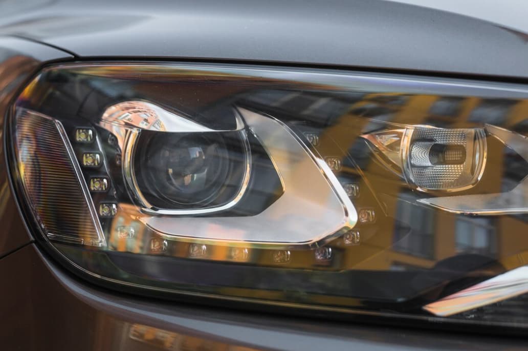 A detailed view of a car's modern headlight with amber accents