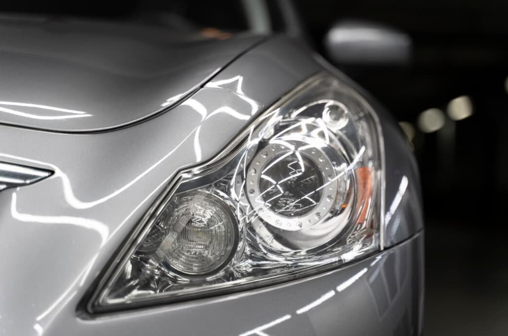 Close-up of a silver car's intricate headlight design
