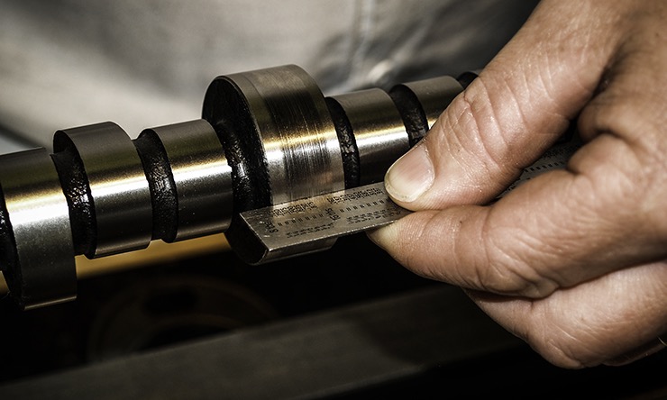 Hands cleaning the camshaft