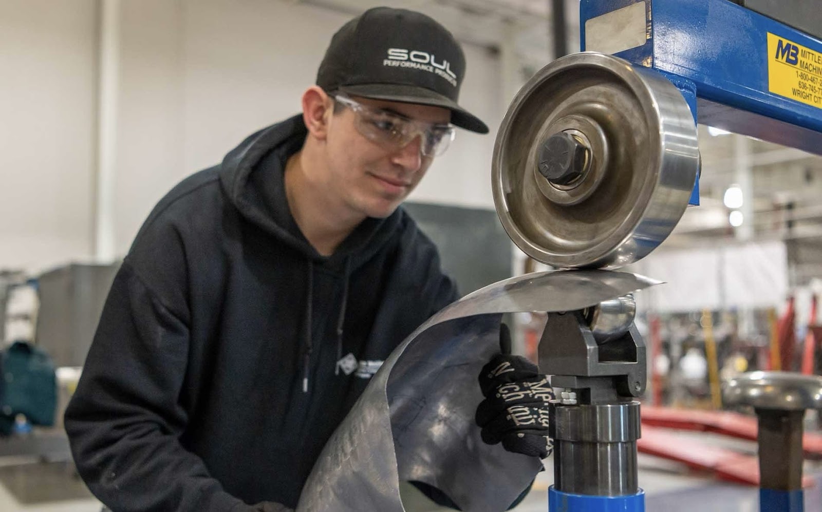 A man processes metal on a machine