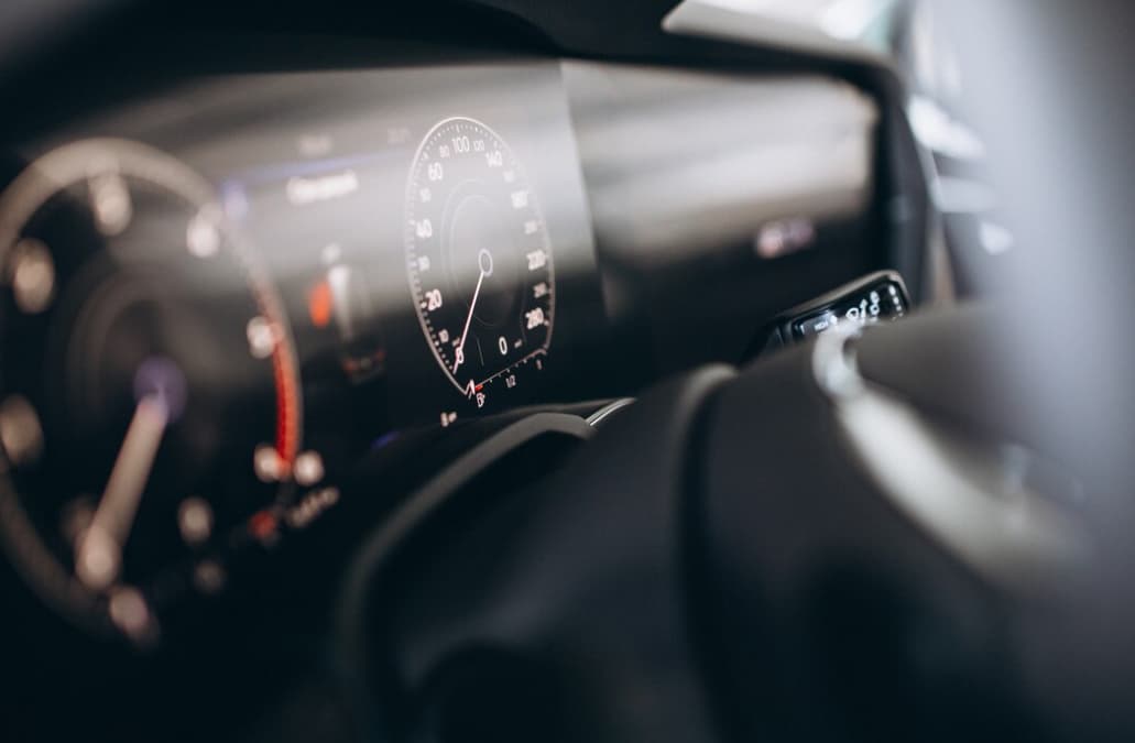 A focused view of a car's illuminated speedometer and fuel gaug