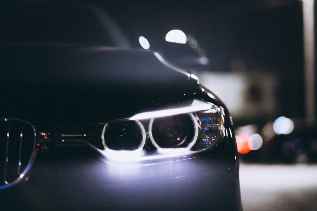 Front car lights at night on the road, the blurred background behind